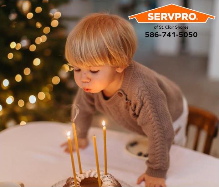 A child blows out candles on a cake during the winter holidays. 