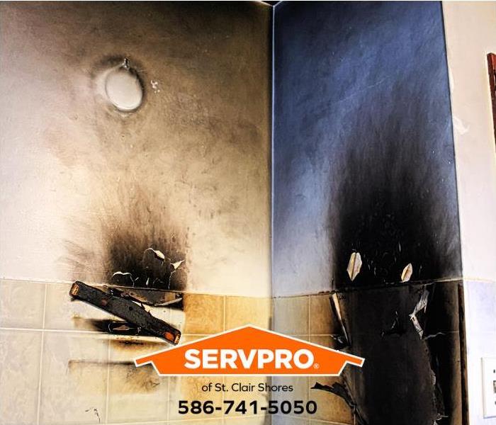 Walls in a fire-damaged kitchen are covered in soot.